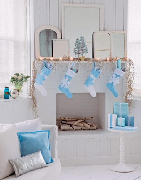 a pretty faux mantel with lights and blue and white stockings with snowflakes to match the decor of the space
