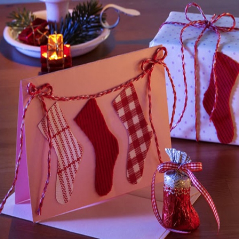 a Christmas card with red yarn and red and white stocking appliques is a cool idea to make for Christmas, it looks nice and is easy to DIY