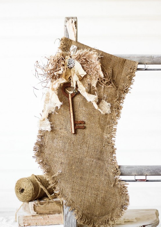 a burlap stocking with some hay, a vintage key and embellishments is a pretty rustic decor idea for a rustic Christmas space