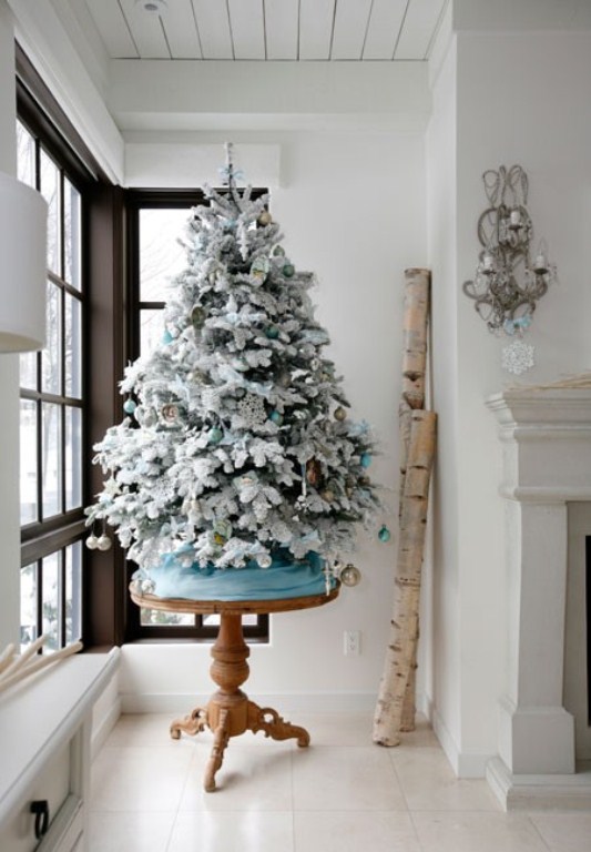a flocked Christmas tree decorated with aqua, metallic and green ornaments is a beautiful idea for a winter wonderland feel
