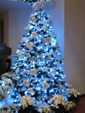 a gorgeous Christmas tree with white decor, fabric blooms and blue lights is a gorgeous idea for an icy and wintry feel in the space