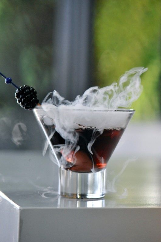 a burgundy cocktail with smoke and a blackberry on top is amazing for Halloween