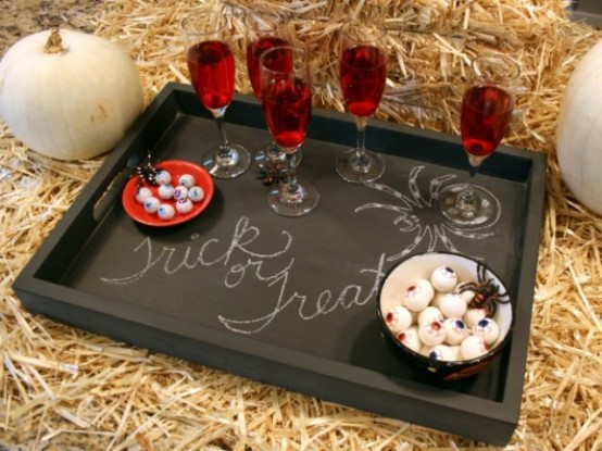 a black chalkboard tray with red drinks, candies and chalking for a rustic Halloween party