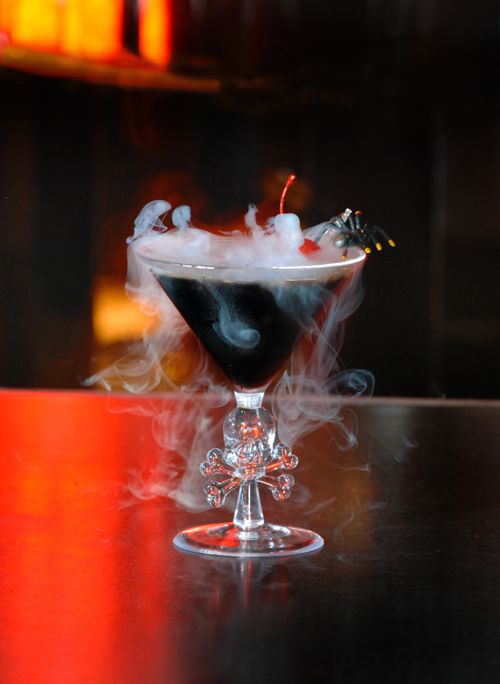 a black Halloween cocktail with smoke, a red cherry and a black spider is perfect for a Halloween party