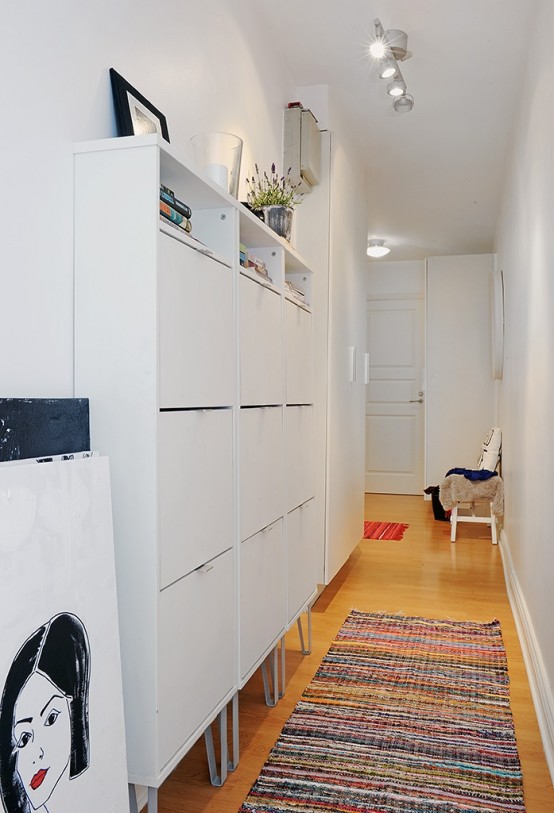 For a narrow hallway you should choose narrow storage solution. You can cover the whole wall with such storage and it won't be look bulky.