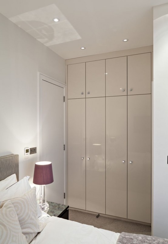 a small and sleek grey wardrobe built into an awkward nook is a cool idea for a modern bedroom and a nice way to make use of this awkward space