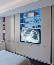 a whole wall taken by wardrobes, with built-in shelves and a TV is a smart idea for a small bedroom, here you may store a lot of things