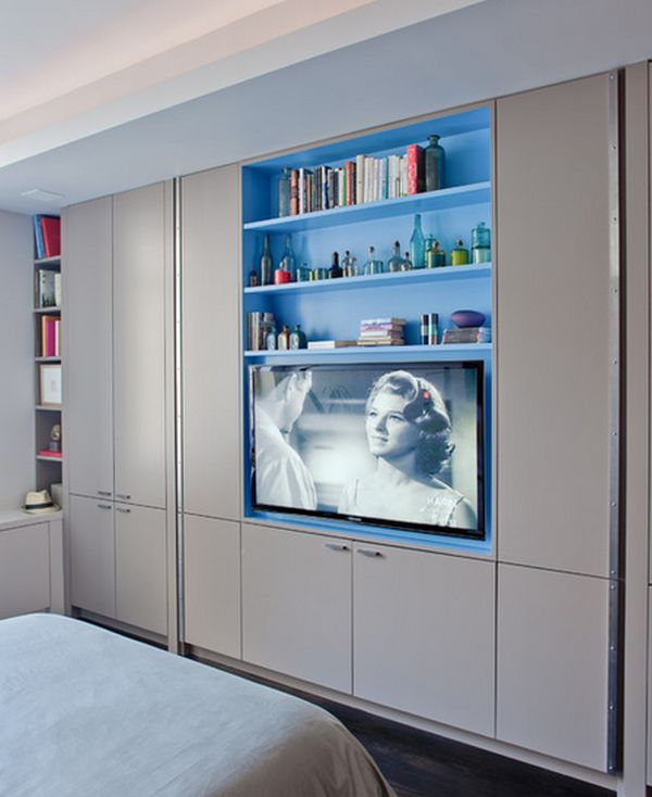a whole wall taken by wardrobes, with built in shelves and a TV is a smart idea for a small bedroom, here you may store a lot of things
