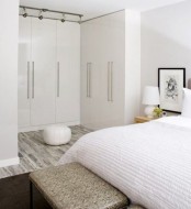 a neutral and stylish bedroom with a whole arrangements of wardrobes forming a personal walk-in closet – that’s a very smart and cool idea