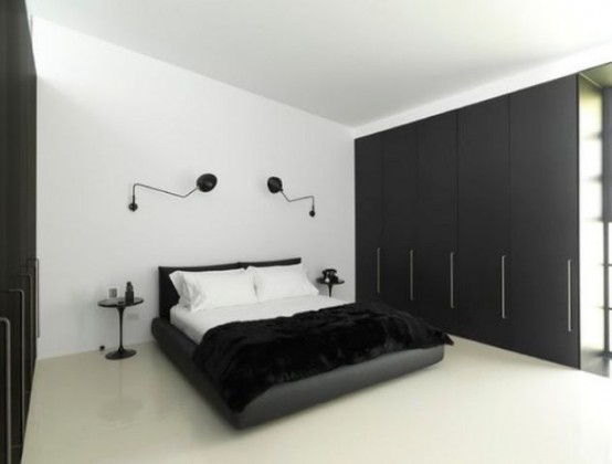 a contrasting bedroom with a couple of sleek black wardrobes that are used for storage and that help to declutter the space