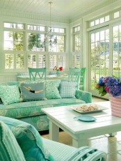 a tiffany blue coastal sunroom with a dining and living room space, with blooms and printed upholstery