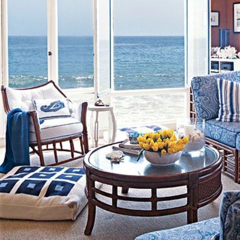 a vintage beach sunroom with dark and blue and white upholstery furniture, a dark table and a marvellous view