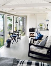 a coastal sunroom with a small kitchen, a small dining space, a couple of chairs and a daybed for spending time almost outdoors