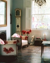 a refined spring living room with vintage touches, with floral chairs, a vintage crystal chandelier, refined decor and clocks