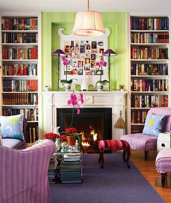 a bright spring living room with green walls, lilac chairs, printed pillows and stools and bold blooms