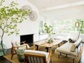 an airy and serene modern living room with neutral furniture, lamps, decorative plates and lots of greenery