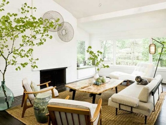 an airy and serene modern living room with neutral furniture, lamps, decorative plates and lots of greenery