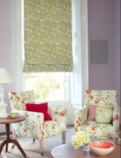 an elegant and cheerful spring living room with lilac walls, floral chairs, a floral curtain, a white lamp and some bright touches