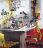 a colorful retro meets boho kitchen in bold red and yellow, a printed chair and lamp