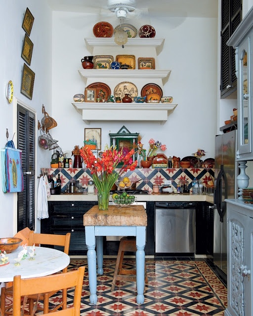 bright printed tiles on the backsplash and floor, colorful artworks and powder blue cabinets