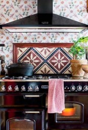 a colorful tile backsplash and an additional backsplash over the cooker