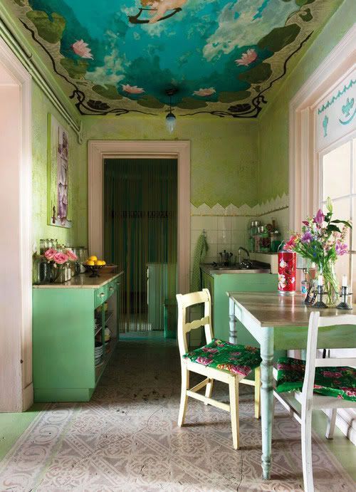 green walls and cabinets, a colorful painted ceiling, bright chairs