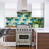 a dark stained and white kitchen with white countertops and a colorful green, yellow and blue tile backsplash is a fun and chic idea