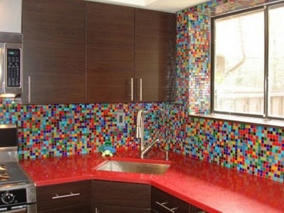 a rich-stained kitchen with bold red countertops and a colorful mosaic tile backsplash and walls that accents the space and makes it non-boring