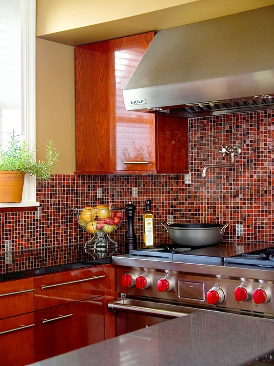 a rich-stained retro kitchen accented with a bold red, burgundy, rust and black tile backsplash and black touches to support the color scheme