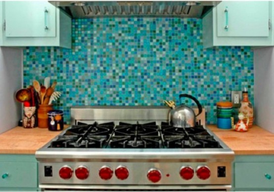 a light blue and mint kitchen with light-stained countertops, a bold turquoise and blue tile backsplash that matches the kitchen colors