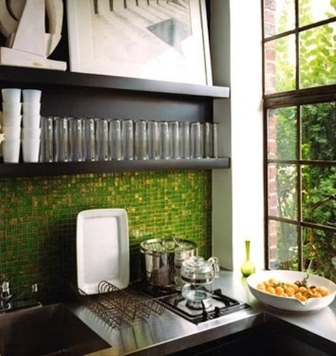 a dark-stained kitchen with open shelves and a grass green mosaic tile backsplash plus a greeneyr view that echoes with this backsplash