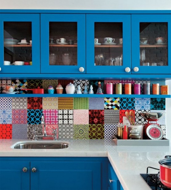 a bright kitchen with teal cabinets, mismatching tile backsplash