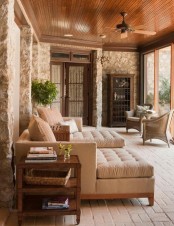 a welcoming modern farmhouse screened porch with neutral upholstered furniture, a storage unit, wicker chairs, stained side tables and greenery