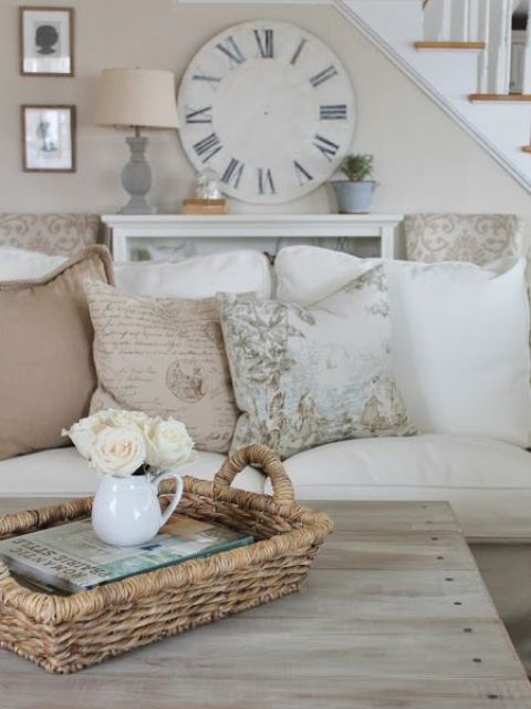 Comfy Farmhouse Living Room Designs To Steal A weathered clock hung on a wall acts as a statement piece in this airy living room.