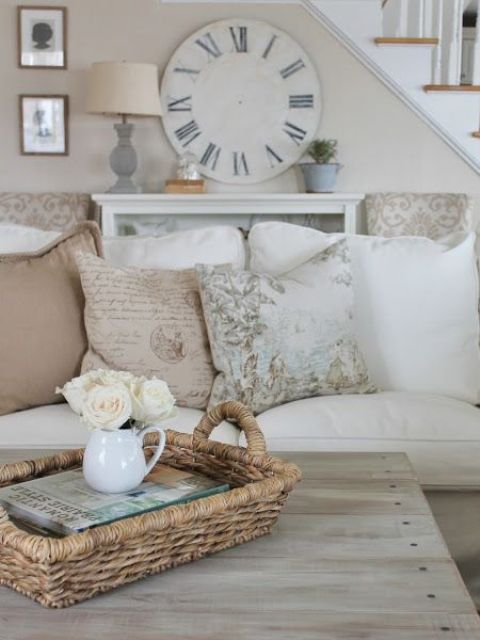 A weathered clock hung on a wall acts as a statement piece in this airy living room.