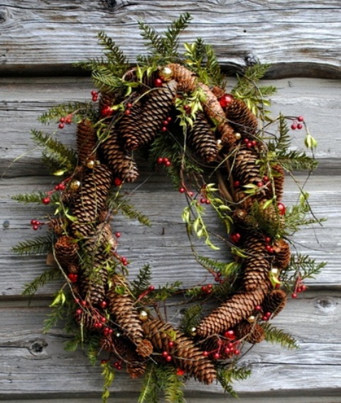 a rustic Christmas wreath of pinecones, greenery and berries is a cozy rustic decor idea for your front door