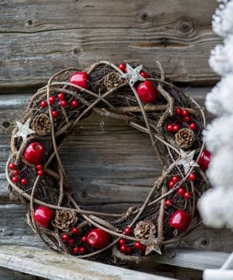 a gorgeous rustic Christma swreath of vine, pinecones, apples, berries and wooden stars is perfect for Scandi winter decor