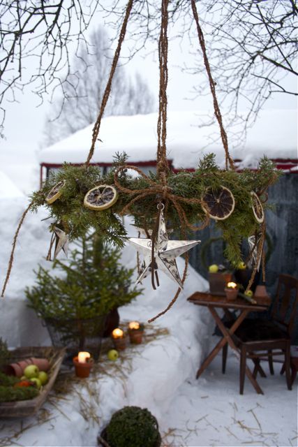 a rustic chandelier of fir branches, dried citrus slices and stars is a fantastic outdoor decoration you can DIY