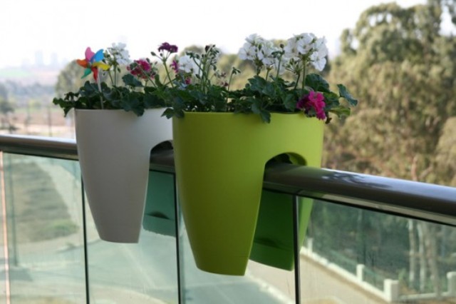 a duo of colorful plastic planters for your blooms can be attached right to the railing of the balcony saving your floor space easily