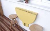 a bright yellow folding table can be attached to the wall in your balcony to hold anything you like and to serve food and drinks
