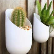 white sleek wall-mounted planters with succulents and cacti are a great decoration for any space, not only a balcony