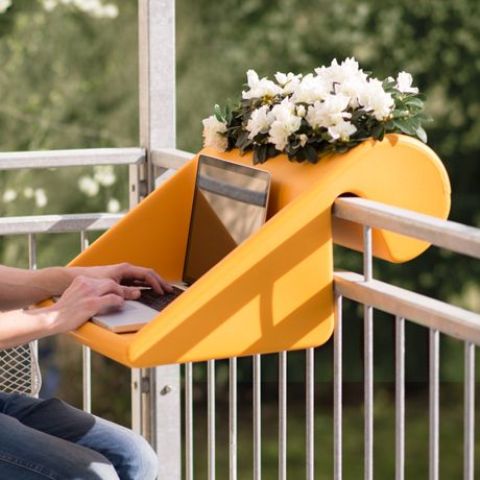 a bright yellow railing desk that doubles as a planter can be a small piece to work on, it's comfortable for a tiny laptop