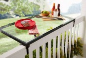 a metal and clear glass railing holder can be used as a table or as a planter holder and it looks seamless as it’s clear