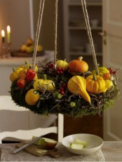 a hanging Thanksgiving wreath of moss, faux berries, twigs and gourds and pumpkins is a lovely idea for Thanksgiving