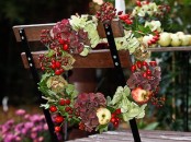 a fall or Thanksgiving wreath of greenery, berries, apples and dark blooms is a chic and very holiday-embracing idea