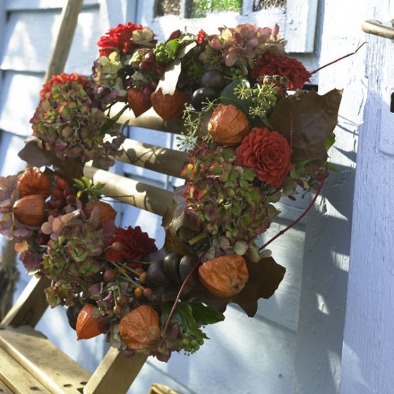 a moody Thanksgiving wreath of dried blooms and fresh greenery plus berries is a textural and lovely idea for the fall or Thanksgiving and it looks very natural