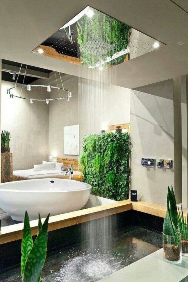 a contemporary neutral bathroom with an oval shaped bathtub and greenery and a rain shower from above that feels like real rain