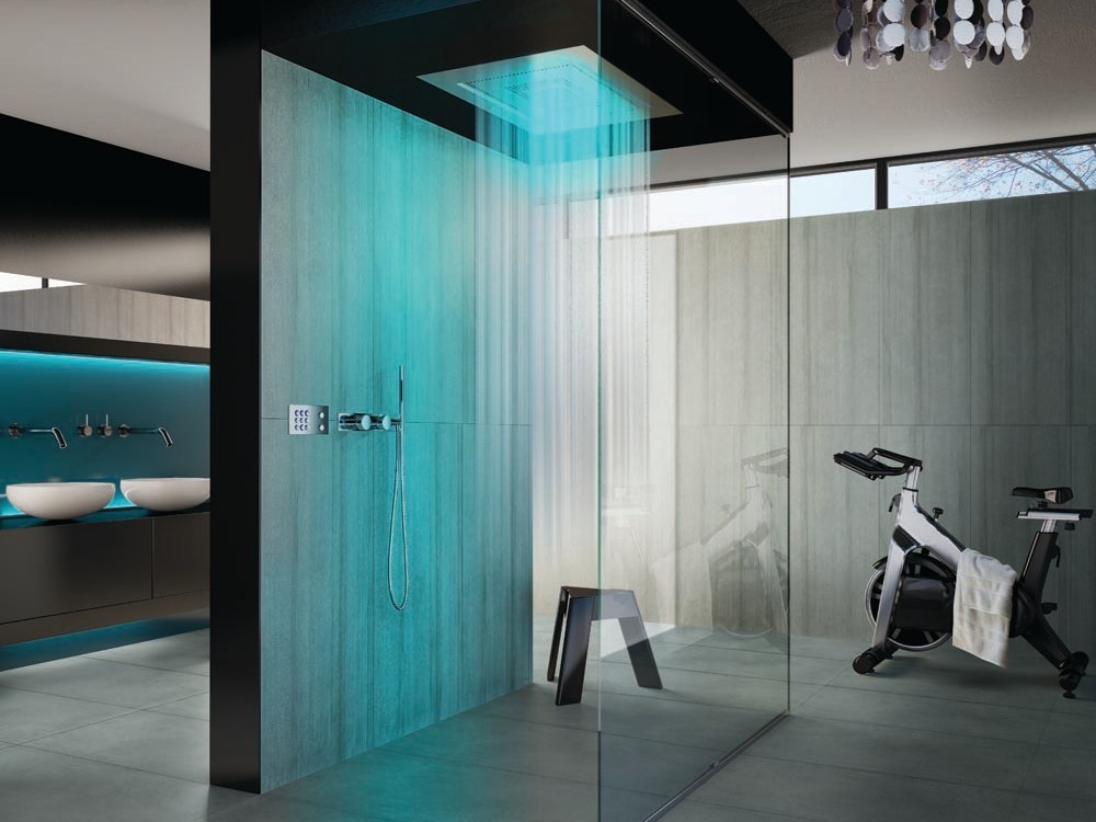 a contemporary bathroom with glass walls and a single stone clad one, with colored lights and a rain shower is a lovely and ultra modern idea