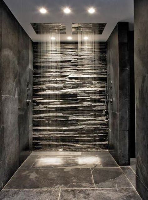 a beautiful shower space clad with stone tiles and with a faux stone wall plus two rain shower heads is a great idea to rock