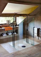 a creative attic shower space enclosed in glass, with a black shower head, with a small window to enjoy natural light
